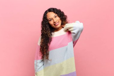 Genç İspanyol kadın neşeli ve kendinden emin bir şekilde gülüyor. Sıradan, mutlu, dostane bir gülümsemeyle.