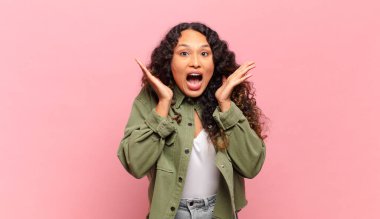 Genç İspanyol kadın beklenmedik bir sürpriz yüzünden şaşkın ve heyecanlı, gülen, şaşkın ve mutlu hissediyor.