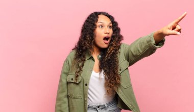 Genç İspanyol kadın şaşkın ve şaşırmış hissediyor, şaşkınlık içinde hayranlıkla bakıyor ve ona bakıyor.