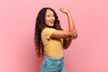 Genç İspanyol kadın kendini mutlu, tatmin olmuş ve güçlü hissediyor, kaslı ve formda, spor salonundan sonra güçlü görünüyor.