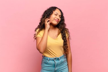 Genç İspanyol kadın stresli, hayal kırıklığına uğramış ve yorgun hissediyordu. Endişeli ve sorunlu bir bakışla boynunu ovuyordu.