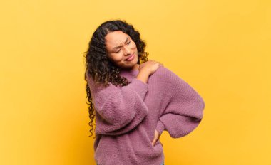 Genç İspanyol kadın yorgun, stresli, endişeli, hayal kırıklığına uğramış ve depresif hissediyor. Sırtı ya da boynu ağrıyormuş.