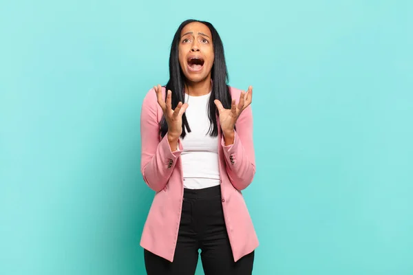 young black woman looking desperate and frustrated, stressed, unhappy and annoyed, shouting and screaming. business concept