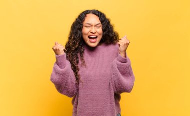 Genç İspanyol kadın son derece mutlu ve şaşırmış görünüyor, başarıyı kutluyor, bağırıyor ve zıplıyor.