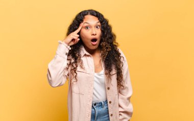 Öfkeli, çılgın bir patrona benzeyen sinirli bir ifadeyle kameraya bakan genç İspanyol kadın.