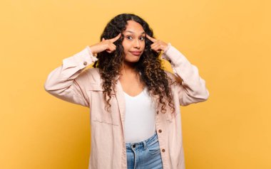 Genç İspanyol kadın konsantre olmuş ve bir fikir üzerinde kafa yoruyor, bir meydan okumaya veya soruna bir çözüm hayal ediyor.