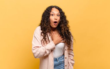 Genç İspanyol kadın şok olmuş ve şaşırmış hissediyor, gülümsüyor, el ele tutuşuyor, o olmaktan mutlu ya da minnettarlık gösteriyor.