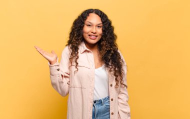 Genç İspanyol kadın mutlu, şaşırmış ve neşeli hissediyor, olumlu bir tavırla gülümsüyor, bir çözüm ya da fikri fark ediyor.