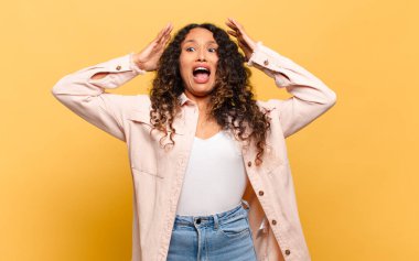 Genç İspanyol kadın ellerini havaya kaldırıp bağırıyor. Öfkeli, sinirli, stresli ve üzgün.