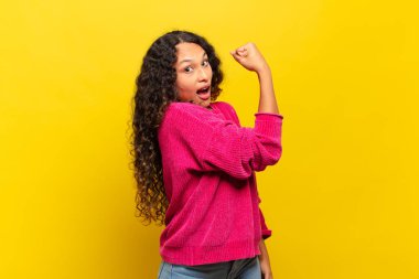 Genç İspanyol kadın kendini mutlu, tatmin olmuş ve güçlü hissediyor, kaslı ve formda, spor salonundan sonra güçlü görünüyor.