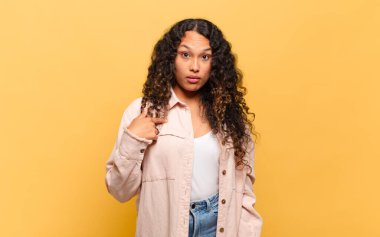 Genç İspanyol kadın şaşkın, şaşkın ve güvensiz hissediyor, kendini gösterip kim olduğunu soruyor, ben mi??