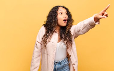 Genç İspanyol kadın şaşkın ve şaşırmış hissediyor, şaşkınlık içinde hayranlıkla bakıyor ve ona bakıyor.