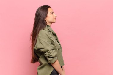 Profil görünümünde genç ve güzel bir kadın ilerideki boşluğu kopyalamaya çalışıyor, düşünüyor, hayal ediyor ya da hayal kuruyor.