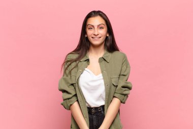 Genç, güzel bir kadın mutlu ve şapşal görünüyor. Geniş, eğlenceli, deli gülüşü ve gözleri açık.