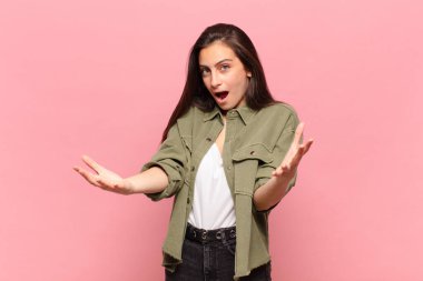 Genç ve güzel bir kadın ağzı açık ve şaşırmış, şok olmuş ve hayrete düşmüş inanılmaz bir sürprizle