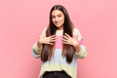 Genç, güzel bir kadın mutlu, şaşırmış, gururlu ve heyecanlı görünüyor.