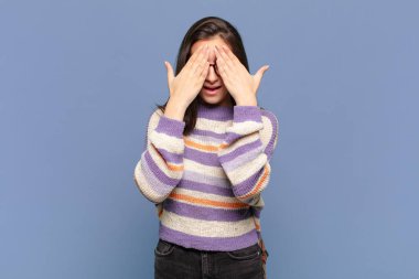 Genç ve güzel bir kadın gülümsüyor ve mutlu hissediyor. İki eliyle gözlerini kapatıyor ve inanılmaz bir sürpriz bekliyor. öğrenci konsepti