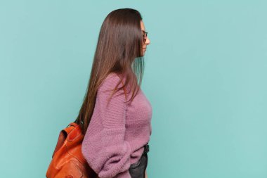 Profil görünümünde genç ve güzel bir kadın uzayı kopyalamaya çalışıyor. Düşünüyor, hayal ediyor ya da hayal kuruyor. öğrenci konsepti