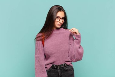 Genç ve güzel bir kadın kibirli, başarılı, pozitif ve gururlu görünüyor, kendini işaret ediyor. öğrenci konsepti