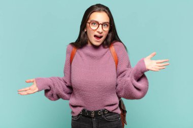 young pretty woman feeling clueless and confused, having no idea, absolutely puzzled with a dumb or foolish look. student concept