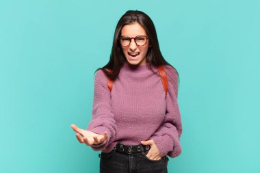 Genç, güzel bir kadın kızgın, sinirli ve sinirli görünüyor. Senin neyin var? öğrenci konsepti 