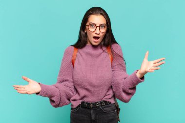 Genç ve güzel bir kadın ağzı açık ve şaşırmış, şok olmuş ve hayrete düşmüş inanılmaz bir sürprizle. öğrenci konsepti