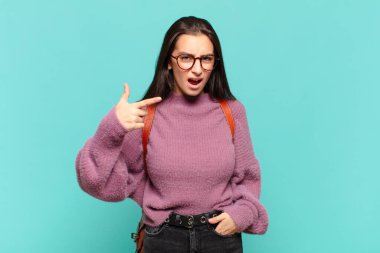 Genç ve güzel bir kadın kızgın agresif bir ifadeyle kameraya bakıyor. Öfkeli, çılgın bir patron gibi görünüyor. öğrenci konsepti