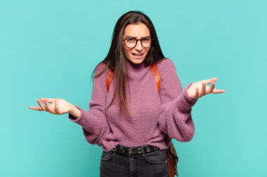 Genç ve güzel bir kadın bilgisiz ve şaşkın hissediyor, hangi seçeneği seçeceğinden emin değil, merak ediyor. öğrenci konsepti