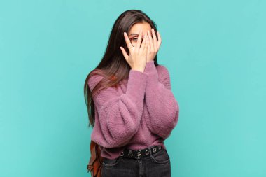 Genç, güzel bir kadın korkmuş ya da utanmış hissediyor. Gözleri yarı kapalı ya da elleri kapalı gözetliyor. öğrenci konsepti