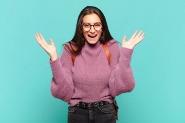 Genç, güzel bir kadın mutlu ve heyecanlı görünüyor. Beklenmedik bir sürprizle şoke olmuş. İki eli de açık. öğrenci konsepti