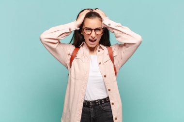 Genç ve güzel bir kadın el ele tutuşuyor, ağzı açık, son derece şanslı, şaşırmış, heyecanlı ve mutlu hissediyor. öğrenci konsepti