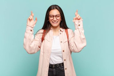 Genç ve güzel bir kadın gergin ve umutlu, dua ediyor ve iyi şanslar diliyor. öğrenci konsepti