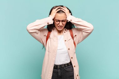 Genç, güzel bir kadın kendini stresli ve hayal kırıklığına uğramış hissediyor. Yumruk yumruğa, yorgun, mutsuz ve migren ağrısı çekiyor. öğrenci konsepti