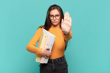 Genç ve güzel bir kadın ciddi, sert, hoşnutsuz ve kızgın görünüyor. öğrenci konsepti