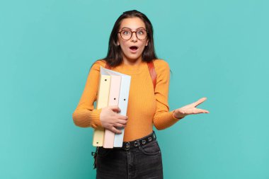 Genç ve güzel bir kadın şok olmuş ve şaşırmış, endişeli ve paniklemiş hissediyor, stresli ve dehşete kapılmış bir bakışla. öğrenci konsepti