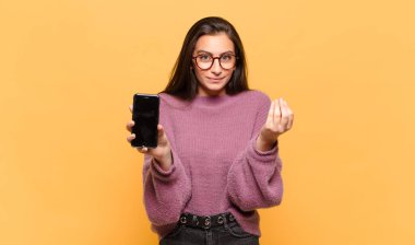 Genç ve güzel bir kadın sana borcunu ödemeni söyleyerek kapiş ya da para hareketi yapıyor. telefon ekranı kavramı