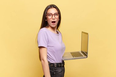 Genç ve güzel bir kadın şok olmuş ya da şaşırmış görünüyor, ağzı açık bir şekilde 