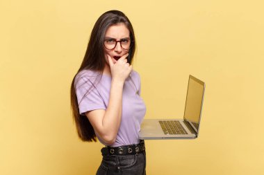 Ağzı ve gözleri açık, eli çenesinde genç ve güzel bir kadın. Hoş olmayan bir şok geçiriyor. Ne diyor? dizüstü bilgisayar