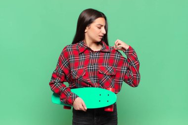 Genç, güzel bir kadın stresli, endişeli, yorgun ve hayal kırıklığına uğramış, gömleğini çekmiş, sorunlu görünüyor. kaykay konsepti