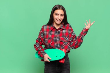 Genç, güzel bir kadın mutlu, şaşırmış ve neşeli, olumlu bir tavırla gülümseyen, bir çözüm ya da fikir gerçekleştiren. kaykay konsepti