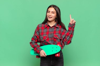 Genç ve güzel bir kadın bir fikri fark ettikten sonra mutlu ve heyecanlı bir dahi gibi hissediyor, neşeli bir şekilde parmağını kaldırıyor, eureka! kaykay konsepti