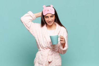 Genç, güzel bir kadın kendini stresli, endişeli, endişeli ya da korkmuş hissediyor. Elleri başının üstünde, hatayla panikliyor. Pijama giyip uyanmak