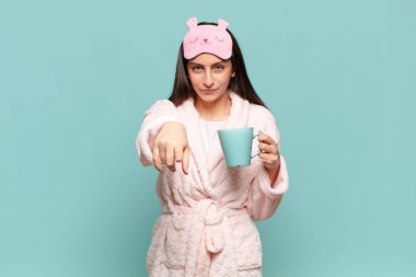 Genç ve güzel bir kadın kameraya bakıyor. Tatmin olmuş, kendinden emin, dostane bir gülümsemeyle. Seni seçiyor. Pijama giyip uyanmak