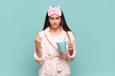 Genç ve güzel bir kadın kızgın, sinirli, isyankar ve agresif hissediyor. Orta parmağını hareket ettiriyor, karşı koyuyor. Pijama giyip uyanmak