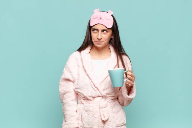 Genç, güzel bir kadın üzgün, üzgün ya da kızgın. Olumsuz bir tavırla yan yana bakıyor, anlaşmazlık içinde kaşlarını çatıyor. Pijama giyip uyanmak