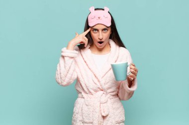 Genç, güzel bir kadın şaşırmış, ağzı açık, şok olmuş, yeni bir düşünce, fikir ya da konsept keşfediyor. Pijama giyip uyanmak