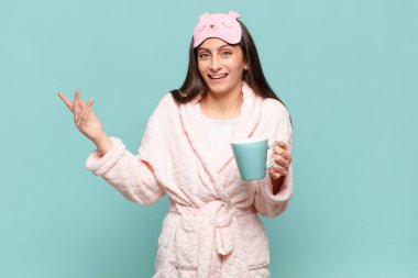 Genç, güzel bir kadın mutlu, şaşırmış ve neşeli, olumlu bir tavırla gülümseyen, bir çözüm ya da fikir gerçekleştiren. Pijama giyip uyanmak