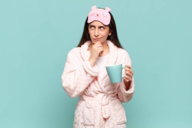 Genç, güzel bir kadın düşünüyor, kuşkulu ve şaşkın hissediyor, farklı seçeneklerle, hangi kararı vereceğini merak ediyor. Pijama giyip uyanmak