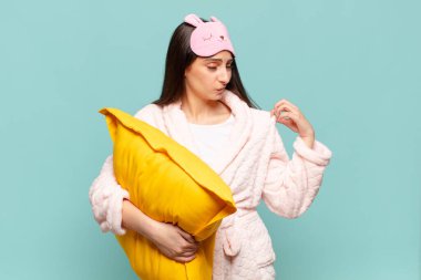 Genç, güzel bir kadın stresli, endişeli, yorgun ve hayal kırıklığına uğramış, gömleğini çekmiş, sorunlu görünüyor. Pijama giyip uyanmak