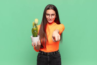 Genç ve güzel bir kadın kameraya bakıyor. Tatmin olmuş, kendinden emin, dostane bir gülümsemeyle. Seni seçiyor. Kaktüs kavramı